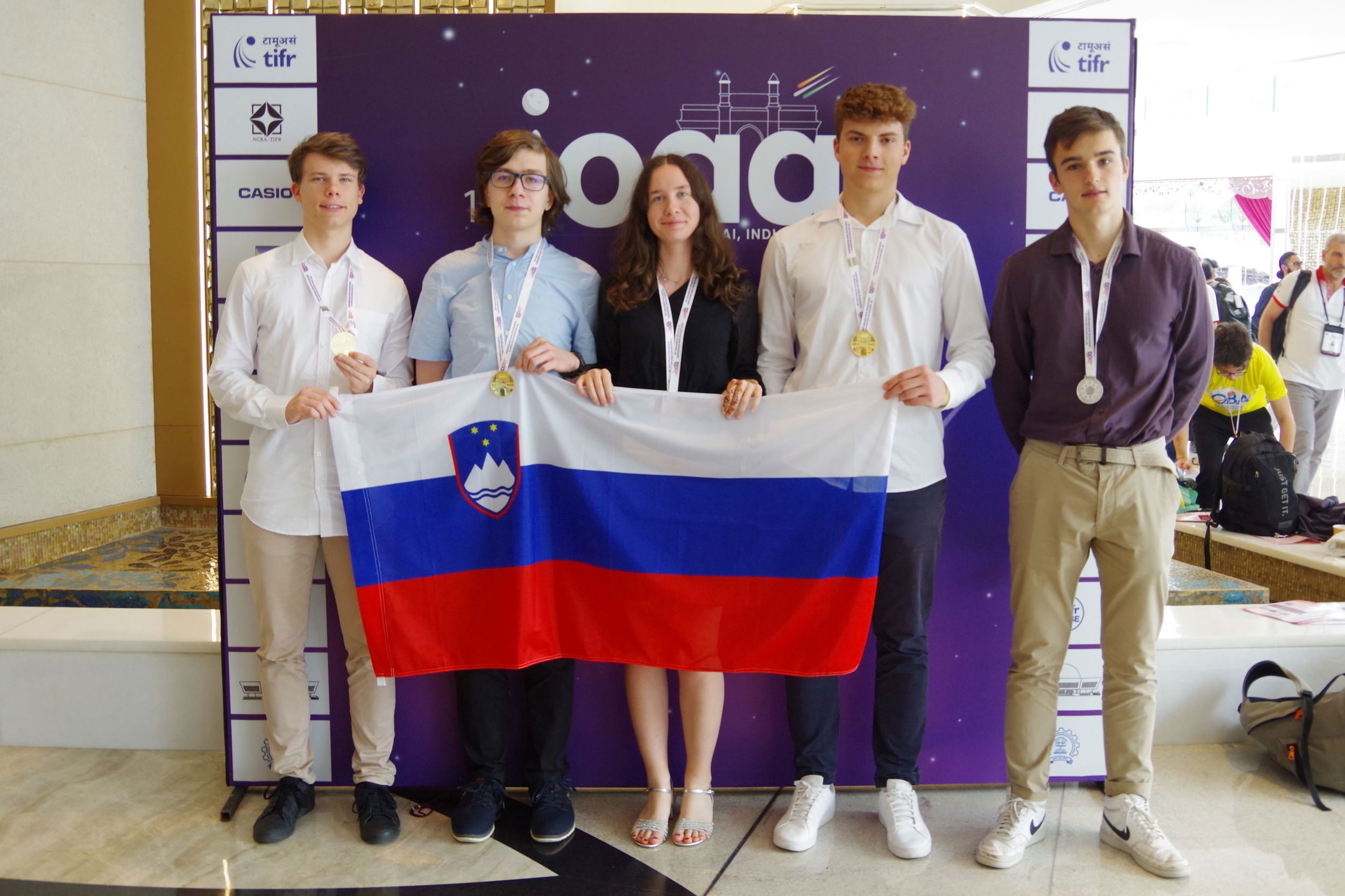 Indija, Mumbaj.
Slovenski dijaki so na mednarodni astrofizikalni olimpijadi v Mubaju osvojili tri zlate, srebrno in bronasto medaljo.
Zmagovalna ekipa po podelitvi nagrad in priznanj. Aljaz Erman (zlata medalja), Primoz Markovic (zlata medalja), Nika Vidensek Podgorelec (bronasta medalja), Zan Arsov (zlata
medalja) in Ziga Vucajnk (srebrna medalja).
Foto: Dunja Fabjan